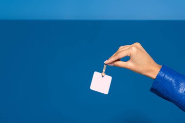 cropped view of african american woman holding blank label on blue background