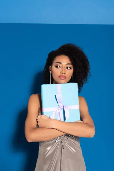 Pensive Mooi Afrikaans Amerikaans Vrouw Zilver Jurk Holding Cadeau Blauwe — Stockfoto