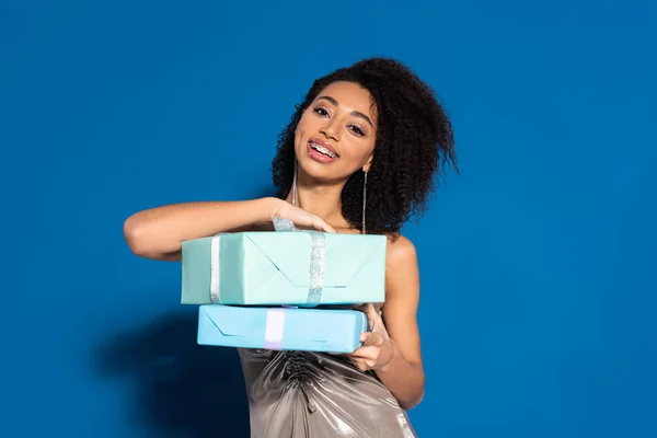 Sonriente Hermosa Mujer Afroamericana Vestido Plata Sosteniendo Regalos Sobre Fondo —  Fotos de Stock