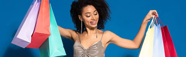 Usmívající Elegantní Africká Američanka Stříbrných Šatech Drží Nákupní Tašky Modrém — Stock fotografie