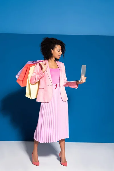 Elegancka Afrykańska Bizneswoman Torbami Zakupy Laptopem Niebieskim Tle — Zdjęcie stockowe