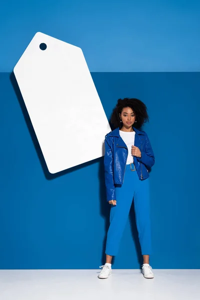 Mujer Afroamericana Cerca Gran Etiqueta Precio Blanco Sobre Fondo Azul — Foto de Stock