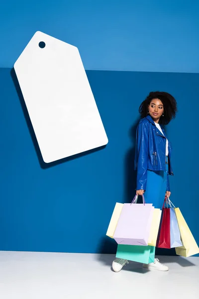Lächelnde Afrikanisch Amerikanische Frau Mit Einkaufstaschen Der Nähe Großer Leerer — Stockfoto