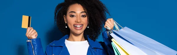 Szczęśliwy Afroamerykanka Kobieta Karty Kredytowej Torby Zakupy Niebieskim Tle Panoramiczne — Zdjęcie stockowe