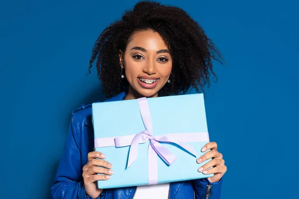 Sonriente Mujer Afroamericana Sosteniendo Presente Sobre Fondo Azul — Foto de Stock