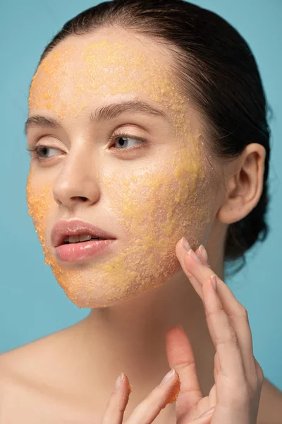 Menina Atraente Aplicando Esfoliação Açúcar Amarelo Rosto Isolado Azul — Fotografia de Stock