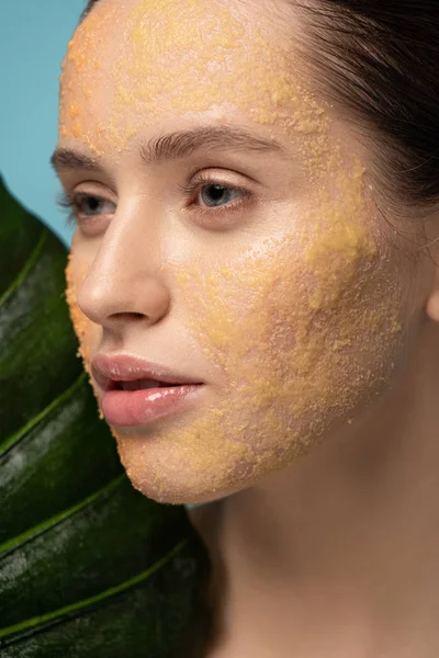 Attraktives Mädchen Mit Zuckerpeeling Gesicht Blatt Haltend Isoliert Auf Blau — Stockfoto