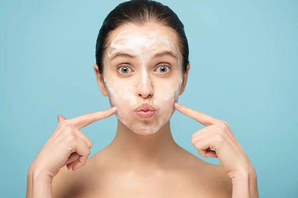 Beautiful Young Woman Cleansing Foam Face Pointing Cheeks Isolated Blue — Stock Photo, Image