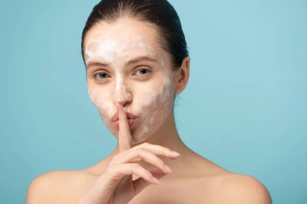 Beautiful Girl Cleansing Foam Face Showing Silence Symbol Isolated Blue — Stock Photo, Image