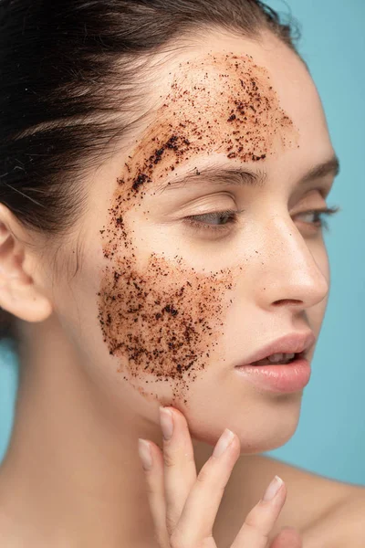 Mooie Jonge Vrouw Aanbrengen Koffie Scrub Gezicht Geïsoleerd Blauw — Stockfoto