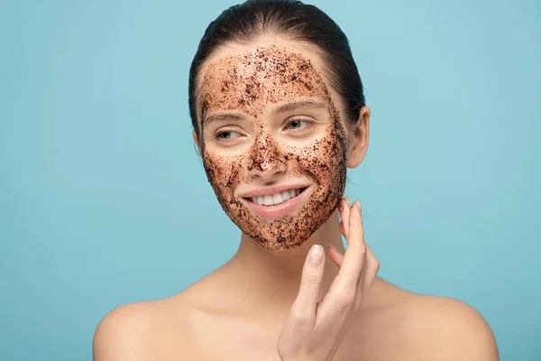 Bela Mulher Sorridente Aplicando Esfrega Café Rosto Isolado Azul — Fotografia de Stock