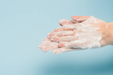 Kırpılmış bir adamın mavi üzerinde ellerini yıkaması görüntüsü 