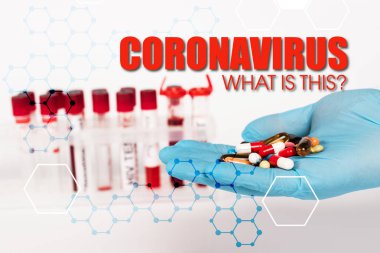 cropped view of scientist in latex glove holding pills near test tubes and coronavirus what is this lettering on white  clipart