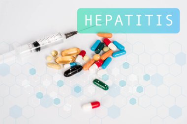 Şırınganın yanında renkli haplar ve beyaz harflerde hepatit. 