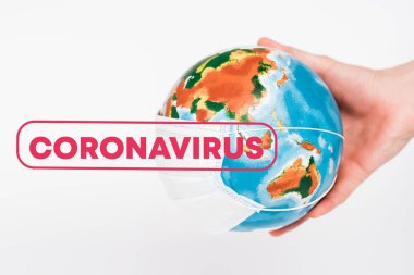 Beyaz harflerle Coronavirus 'un yanında kürenin koruyucu maskesini tutan adamın görüntüsü. 