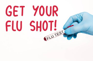 cropped view of scientist holding test tube with flu test near get your flu shot lettering on white  clipart