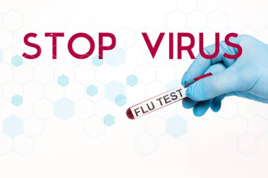 Beyaz harflerle yazılmış virüsü durdurmak için grip testi yapan bir bilim adamının elinde test tüpü var. 