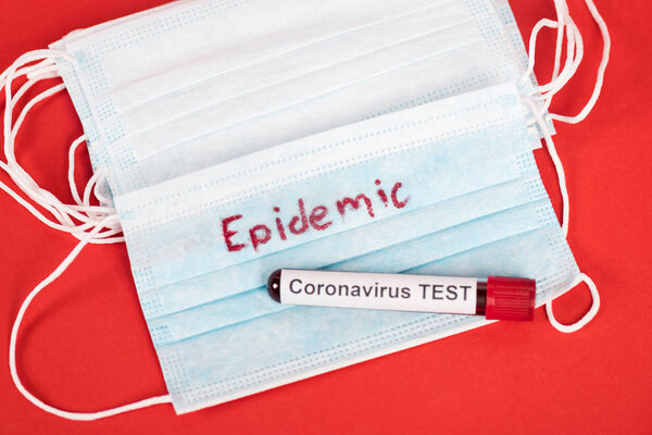 top view of sample with coronavirus test near protective medical masks with epidemic lettering on red 
