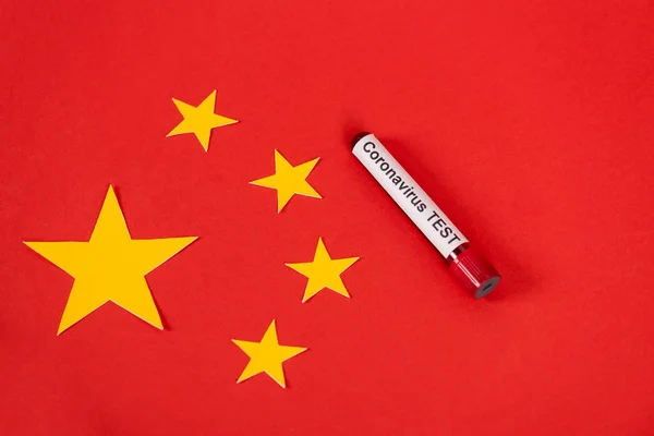 top view of sample with coronavirus test lettering near red chinese flag 
