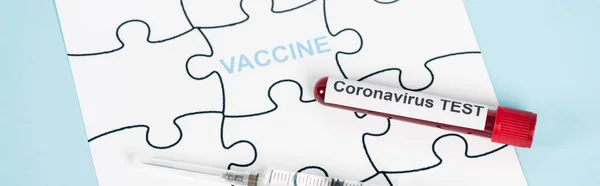 ワクチンレタリング付きパズルピースのパノラマ写真コロナウイルス検査と青の注射器でサンプルの近く — ストック写真