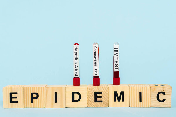samples with blood on wooden cubes with epidemic lettering isolated on blue 
