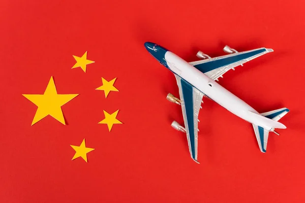 红色中国国旗上的玩具飞机俯瞰图 — 图库照片