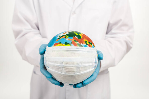 cropped view of scientist holding globe in protective mask isolated on white 