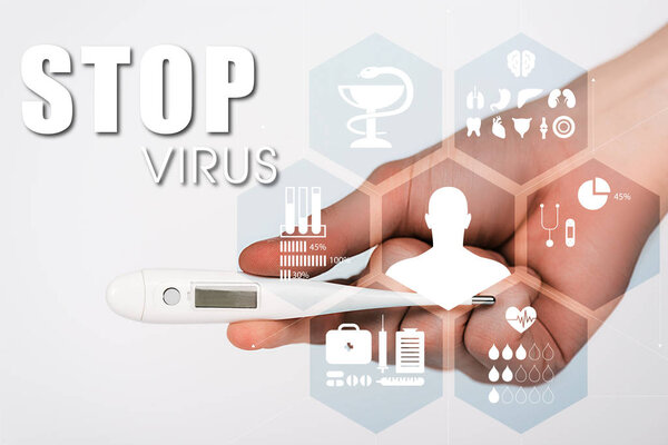 cropped view of woman holding digital thermometer near stop virus lettering on white 