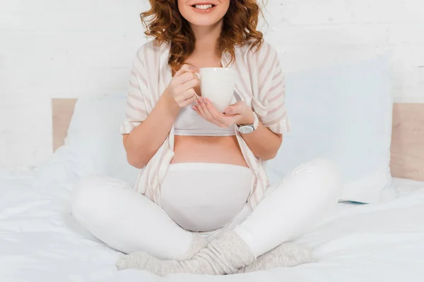 Vista Recortada Una Mujer Embarazada Sonriente Sosteniendo Taza Cama — Foto de Stock