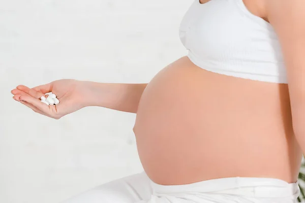 Vista Recortada Mujer Embarazada Sosteniendo Píldoras Sobre Fondo Blanco — Foto de Stock