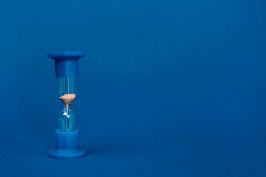 mavi arkaplanda kopyalama alanı olan parlak ve renkli kum saati 