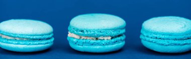 panoramic shot of french macaroons on blue background  clipart