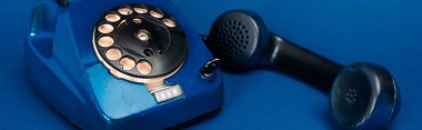 mavi arkaplanda retro telefonun panoramik görüntüsü 