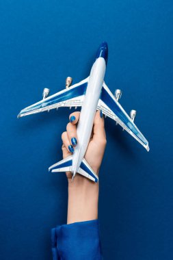 Mavi arka planda uçak modelini tutan kadın görüntüsü 