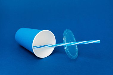 boş kağıt bardak ve mavi arkaplanda plastik saman 
