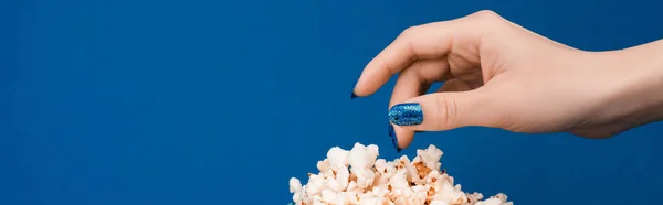 ブルーに隔離されたポップコーンを飲んでいる女性のパノラマ写真 — ストック写真