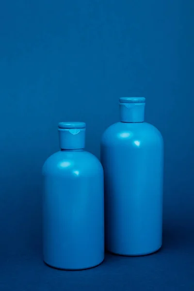 コピースペース付きの青い背景にシャンプー付きのペットボトル — ストック写真