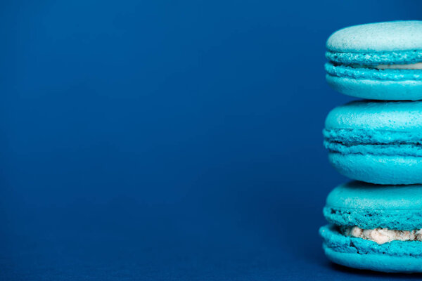 sweet french macaroons on blue background with copy space 