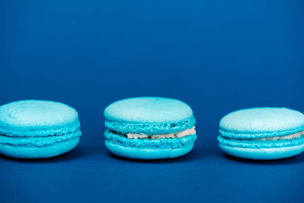 вкусные французские макароны на синем фоне с копировальным пространством
 