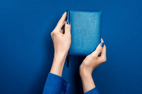 Περικοπή Άποψη Της Γυναίκας Κρατώντας Σημειωματάριο Μπλε Φόντο — Φωτογραφία Αρχείου