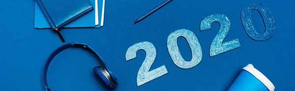 Foto Panoramica Notebook Cuffie Penna Cucitrice Numeri 2020 Sfondo Blu — Foto Stock