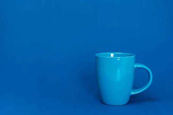 cup of coffee on blue background with copy space