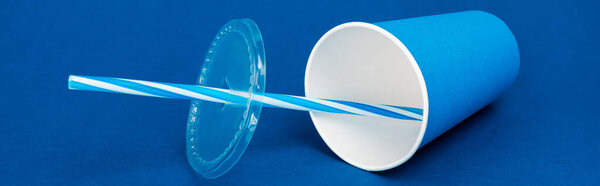 panoramic shot of paper cup with soda on blue background 