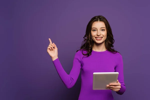 Cheerful Girl Holding Digital Tablet Pointing Finger Purple Background — Stock Photo, Image