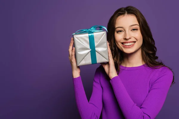 Cheerful Girl Showing Gift Box While Smiling Camera Purple Background — Stock Photo, Image