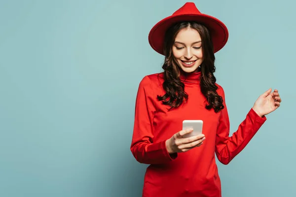 Vrolijk Stijlvol Meisje Glimlachen Terwijl Chatten Smartphone Blauwe Achtergrond — Stockfoto