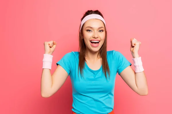 Vrolijke Sportvrouw Tonen Winnaar Gebaar Terwijl Glimlachen Camera Roze Achtergrond — Stockfoto