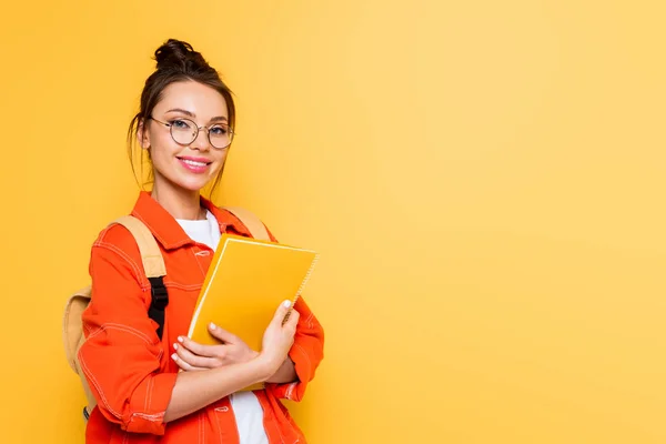 Vidám Tanuló Szemüvegben Nézi Kamerát Miközben Tartja Notebook Izolált Sárga — Stock Fotó