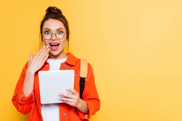 Sorprendido Estudiante Sosteniendo Mano Cerca Boca Mientras Sostiene Tableta Digital —  Fotos de Stock