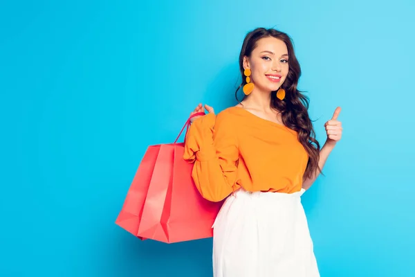 Cheerful Fashionable Girl Holding Shopping Bags Showing Okay Gesture Blue — Stock Photo, Image